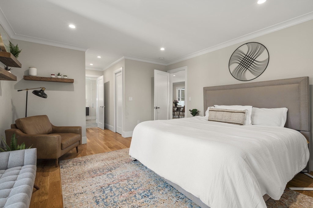 148 Kent Street, Unit 148 Brookline, MA 02446 - Photo 9 of 19 a spacious bedroom with a bed and a chandelier