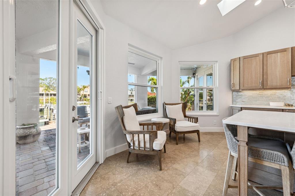 123 8th Street East Tierra Verde, FL 33715 - Photo 27 of 87 a living room with furniture a fireplace and a dining table with wooden floor