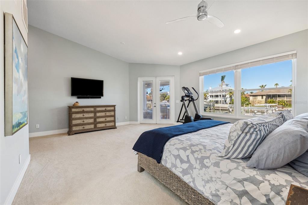 123 8th Street East Tierra Verde, FL 33715 - Photo 35 of 87 a spacious bedroom with a bed and a flat screen television