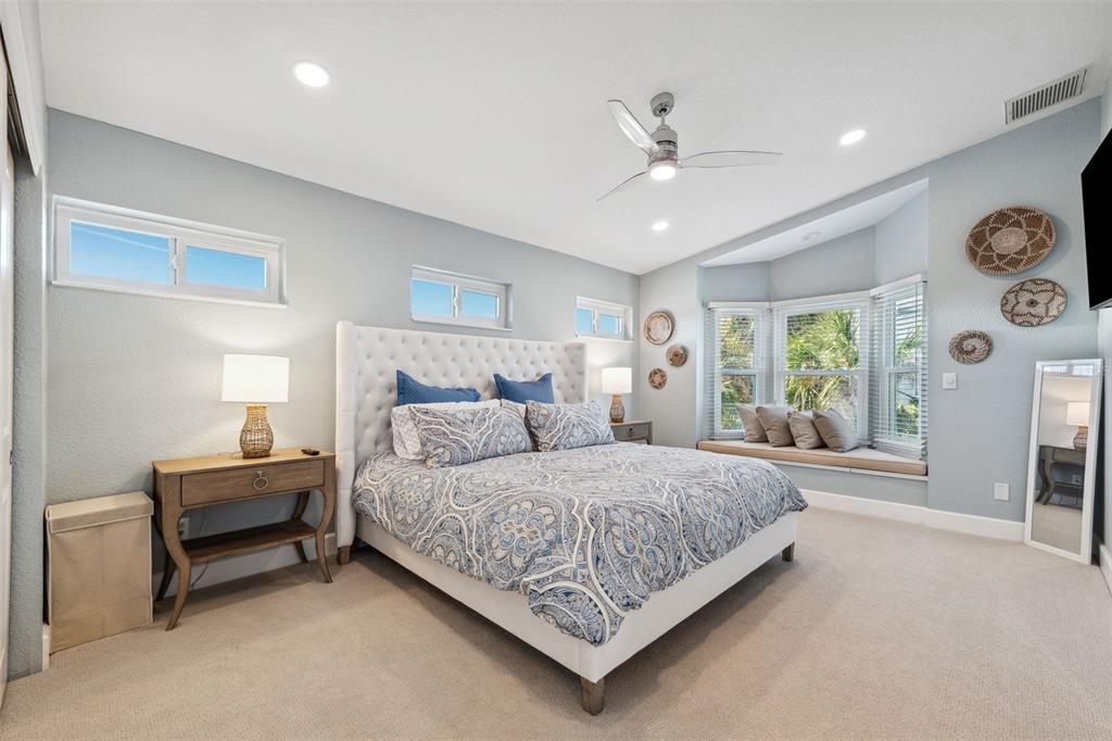 123 8th Street East Tierra Verde, FL 33715 - Photo 44 of 87 a bedroom with a large bed and a chandelier