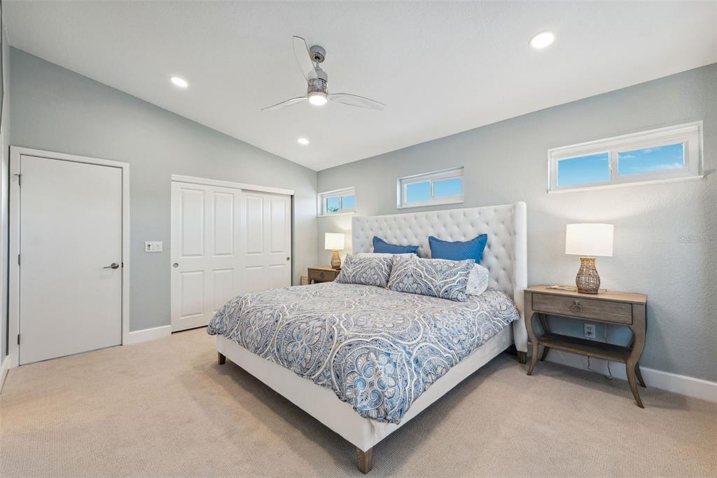 123 8th Street East Tierra Verde, FL 33715 - Photo 45 of 87 a bedroom with a bed chandelier and a window