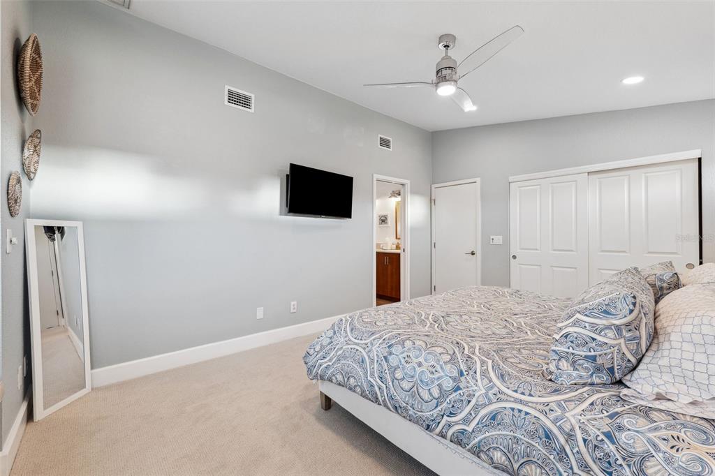 123 8th Street East Tierra Verde, FL 33715 - Photo 46 of 87 a spacious bedroom with a bed and a flat screen tv