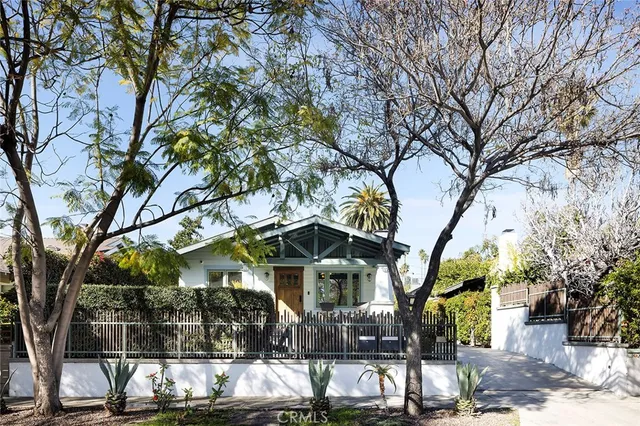 a front view of a house with a tree