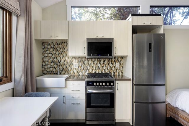 a kitchen with white cabinets and stainless steel appliances