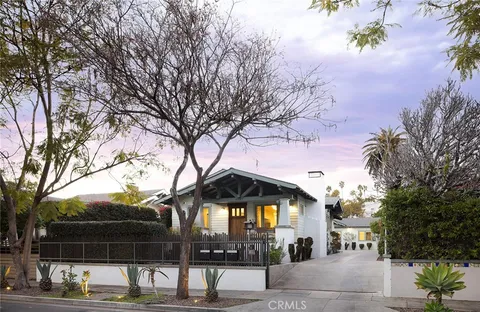 a front view of a house with a tree