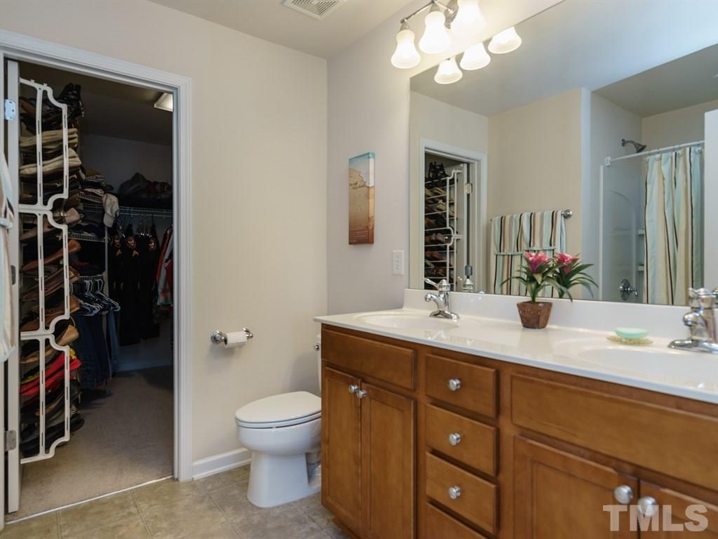8326 Pilots View Drive Raleigh, NC 27617 - Photo 17 of 25 a bathroom with a granite countertop sink a toilet and a mirror