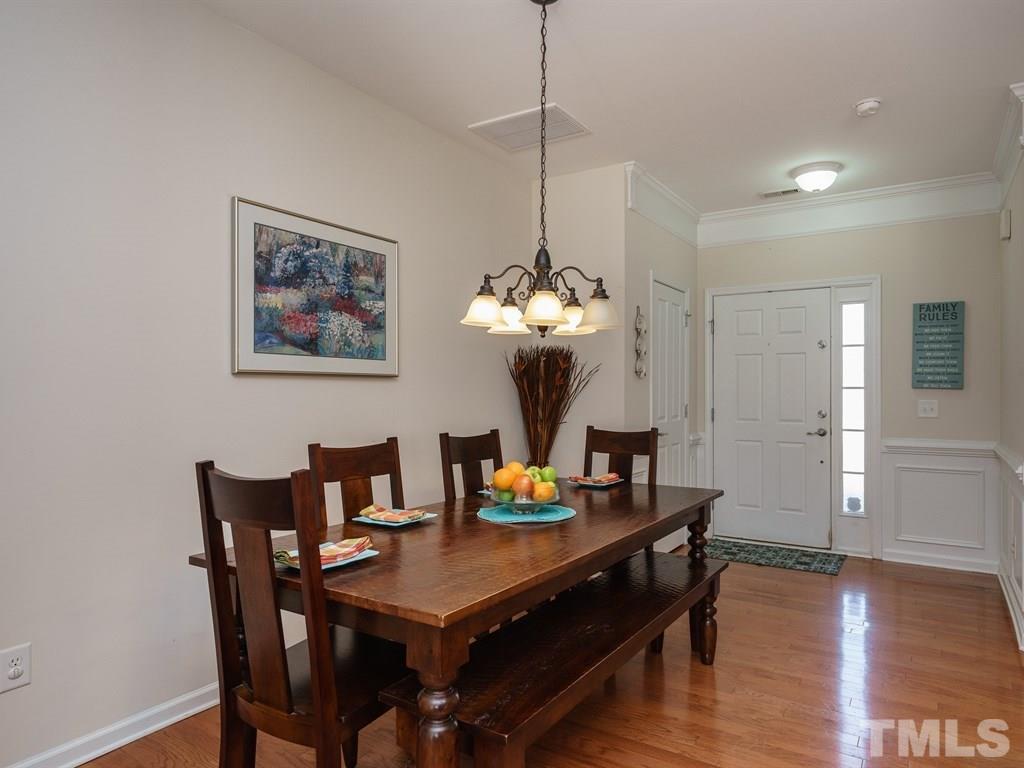 8326 Pilots View Drive Raleigh, NC 27617 - Photo 7 of 25 a view of a dining room with furniture a chandelier and wooden floor