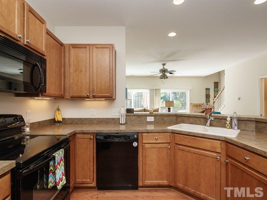 8326 Pilots View Drive Raleigh, NC 27617 - Photo 9 of 25 a kitchen with stainless steel appliances granite countertop a sink stove and microwave