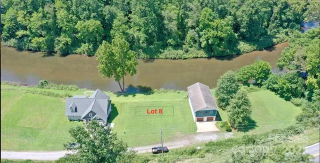 an aerial view of a house with a yard and lake view