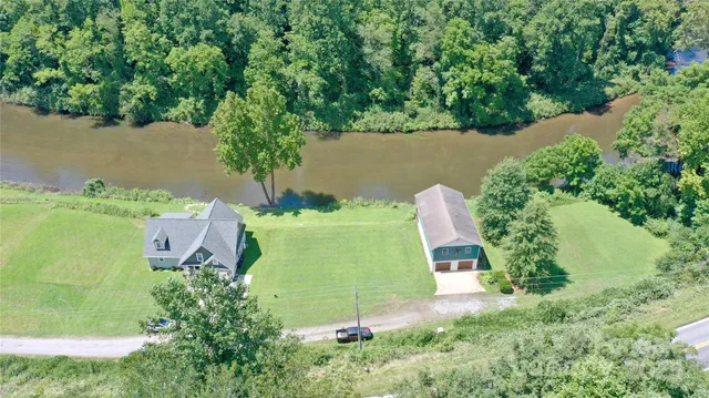 an aerial view of a house with a yard and lake view