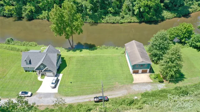 an aerial view of a house with a yard and lake view