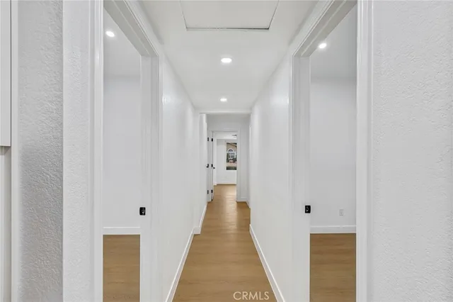 a view of a hallway with wooden floor