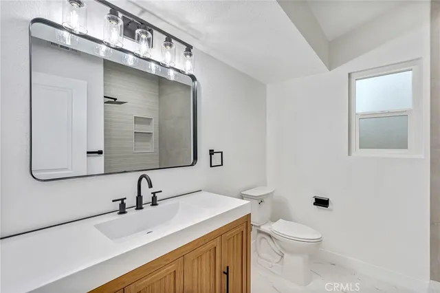a bathroom with a sink a toilet and mirror