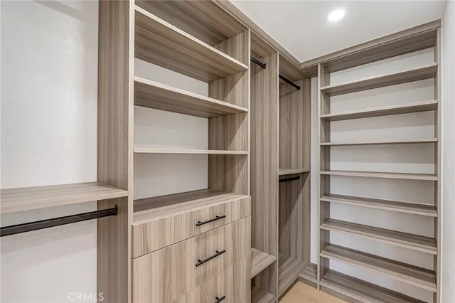 a view of walk in closet with empty racks