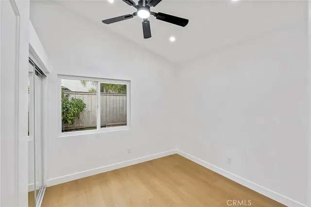 an empty room with a window and a fan