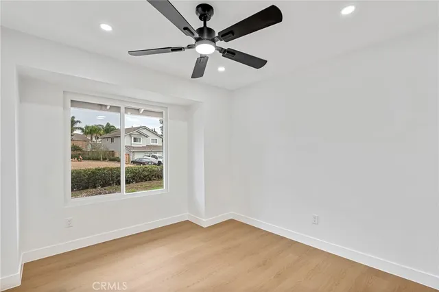 an empty room with a window and a fan