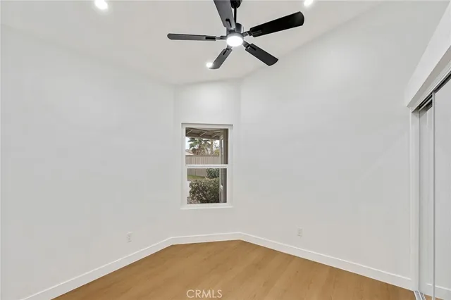 an empty room with a window and a fan