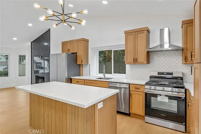 a kitchen with stainless steel appliances a stove a sink and a refrigerator