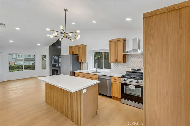 a large kitchen with stainless steel appliances granite countertop a stove and a refrigerator