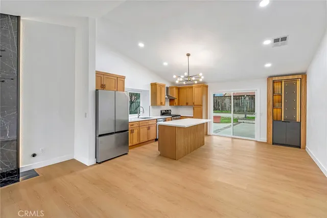 a large kitchen with a refrigerator a sink dishwasher with a dining table and chairs