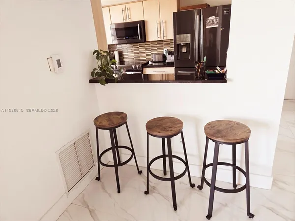 a kitchen with stainless steel appliances kitchen island a refrigerator and cabinets