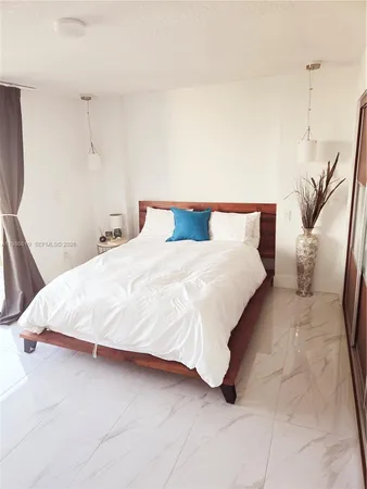 a large bed sitting in a bedroom and a table