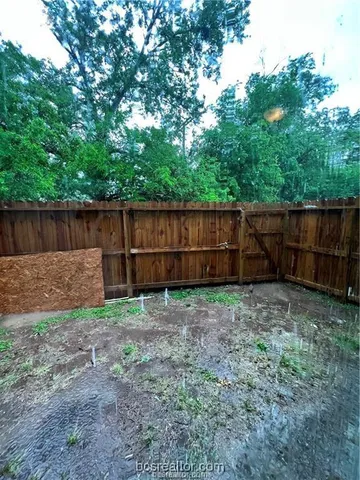 a view of backyard with wooden fence