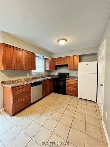 a kitchen with stainless steel appliances granite countertop a stove a sink dishwasher and a refrigerator