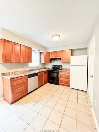 a kitchen with stainless steel appliances granite countertop a stove top oven a sink and a refrigerator