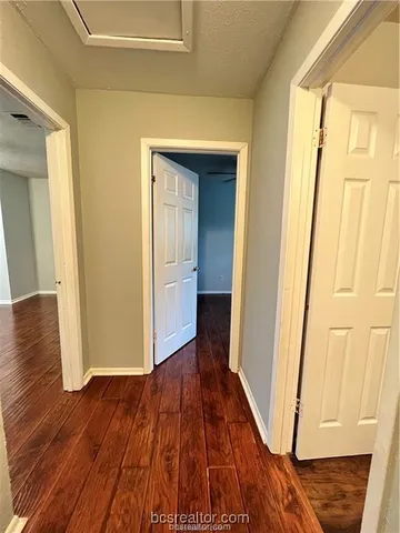 a view of a hallway with wooden floor and staircase