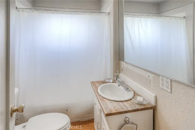 a bathroom with a granite countertop sink toilet and a mirror