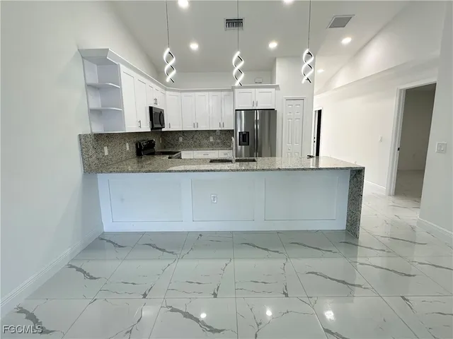 a large kitchen with kitchen island a sink a counter and stainless steel appliances
