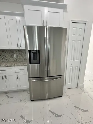 a metallic refrigerator freezer sitting in a kitchen