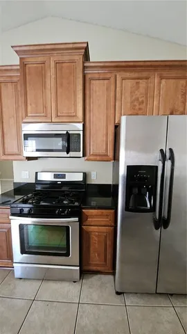 a kitchen with stainless steel appliances granite countertop a stove microwave and refrigerator
