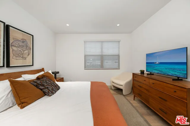 a bedroom with a bed and flat screen tv