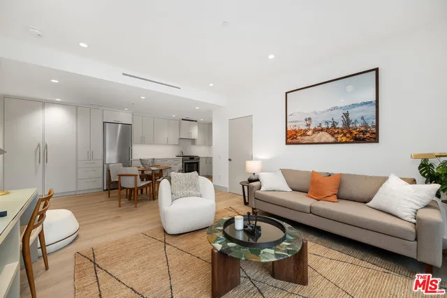 a living room with furniture and a dining table with wooden floor