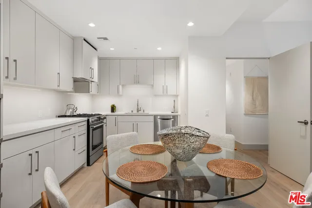 a kitchen with a sink white cabinets and stainless steel appliances