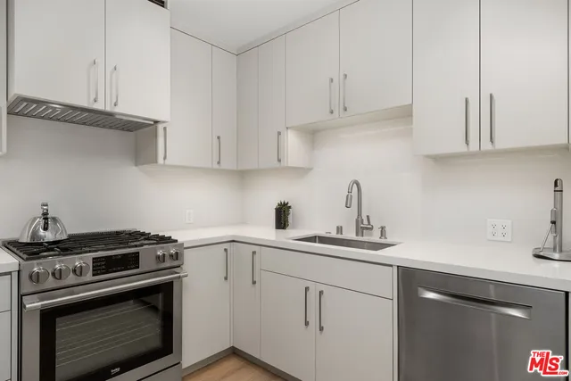 a kitchen with cabinets appliances a sink and a counter top