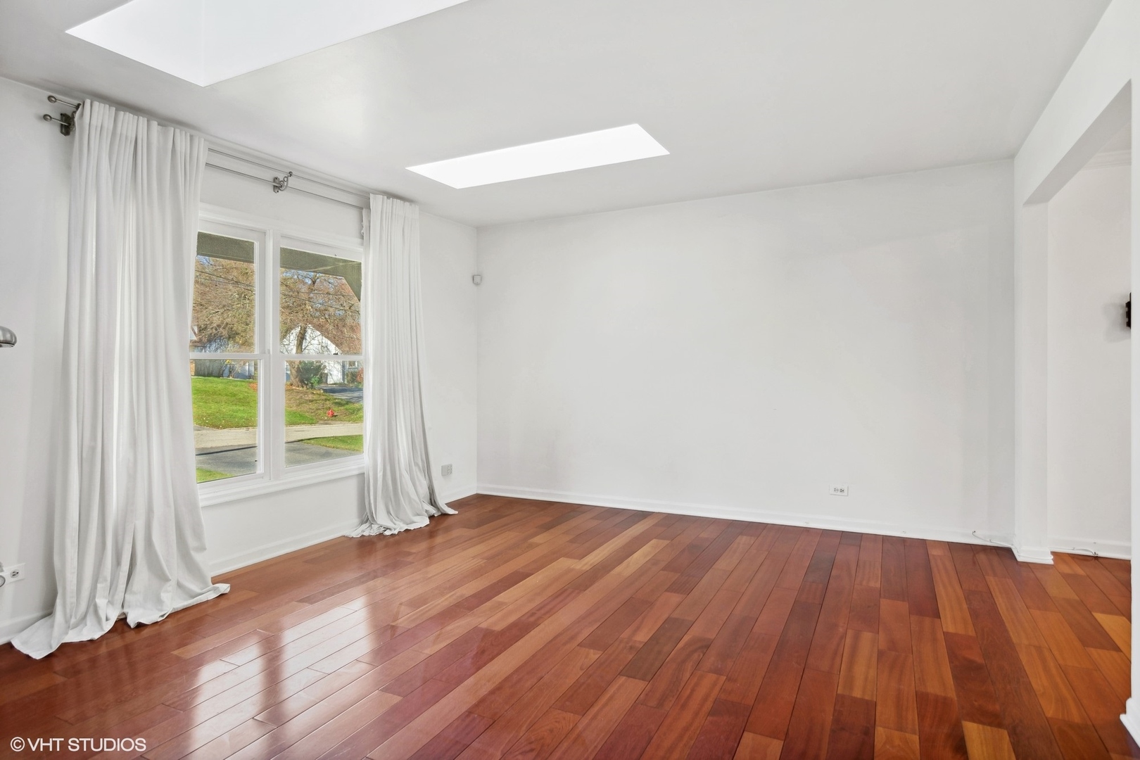 245 Thomas Street Cary, IL 60013 - Photo 3 of 28 a view of an empty room with wooden floor and a window