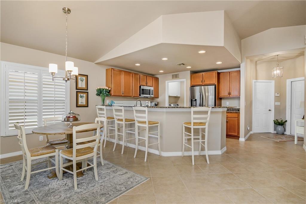 19633 Villa Rosa Loop Estero, FL 33967 - Photo 12 of 50 Kitchen featuring lofted ceiling, hanging light fixtures, stainless steel appliances, and a chandelier
