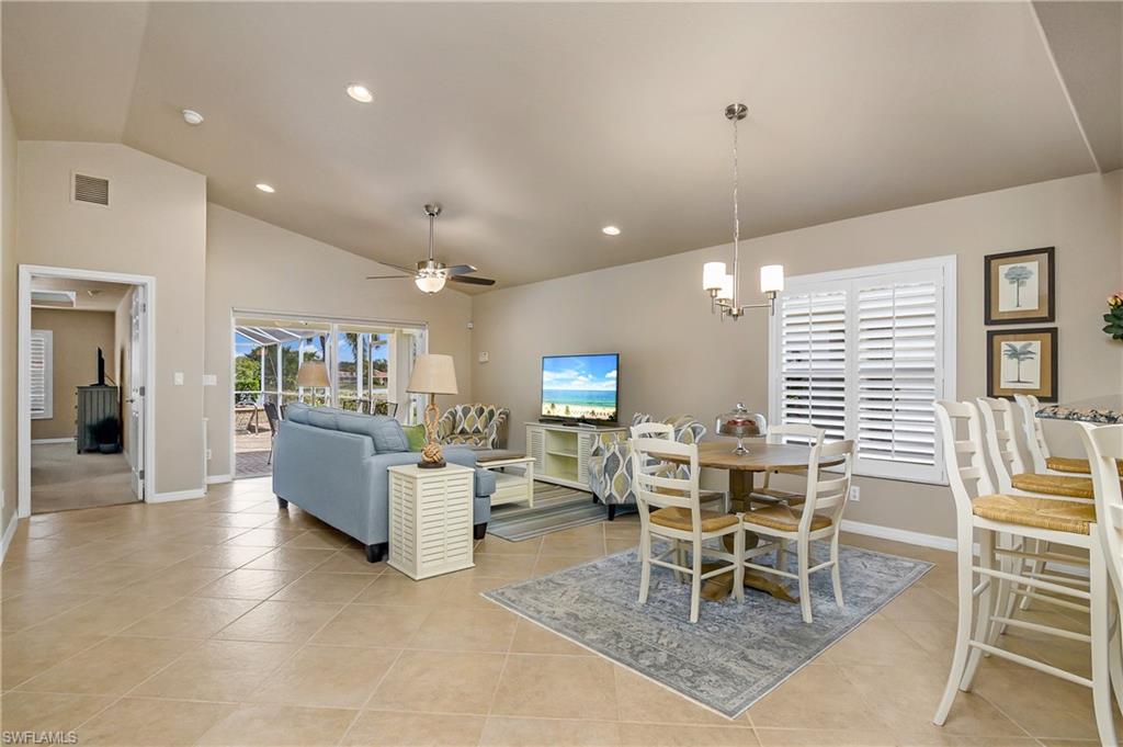 19633 Villa Rosa Loop Estero, FL 33967 - Photo 13 of 50 Tiled dining room with ceiling fan with notable chandelier and vaulted ceiling