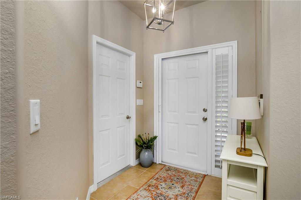 19633 Villa Rosa Loop Estero, FL 33967 - Photo 8 of 50 Foyer entrance featuring light tile patterned floors and a notable chandelier