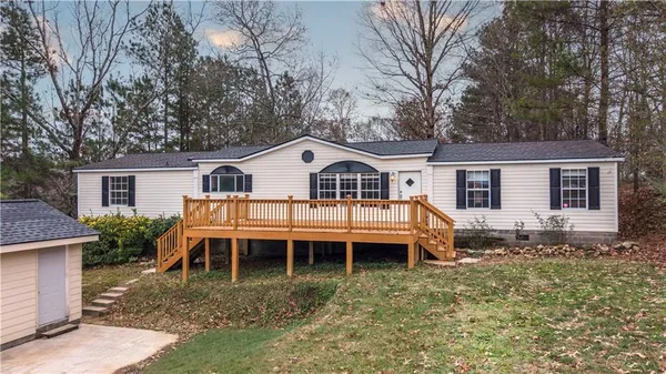a view of house with a yard and deck