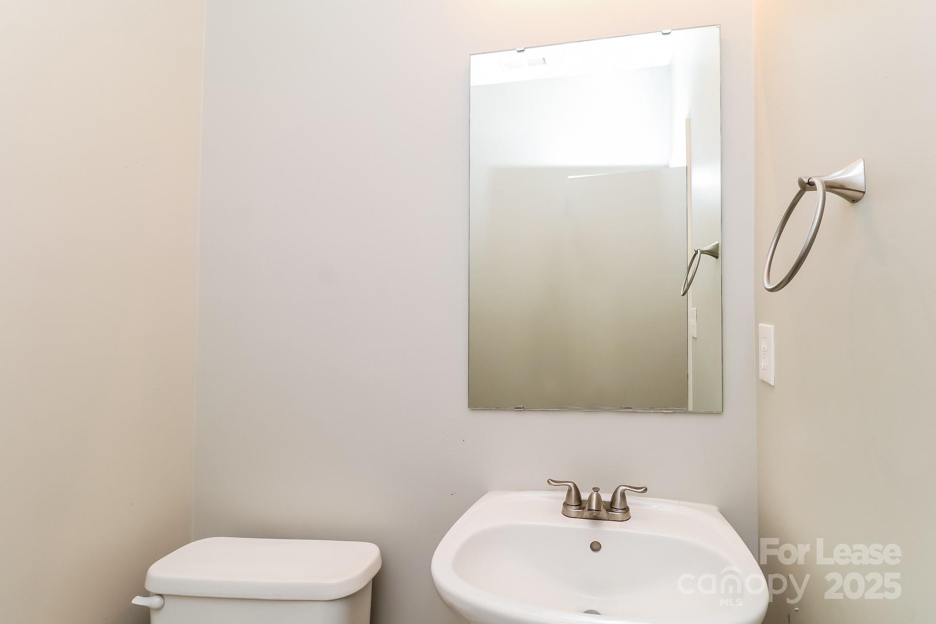 10901 Slalom Hill Road Charlotte, NC 28278 - Photo 13 of 17 a bathroom with a white sink a toilet and mirror