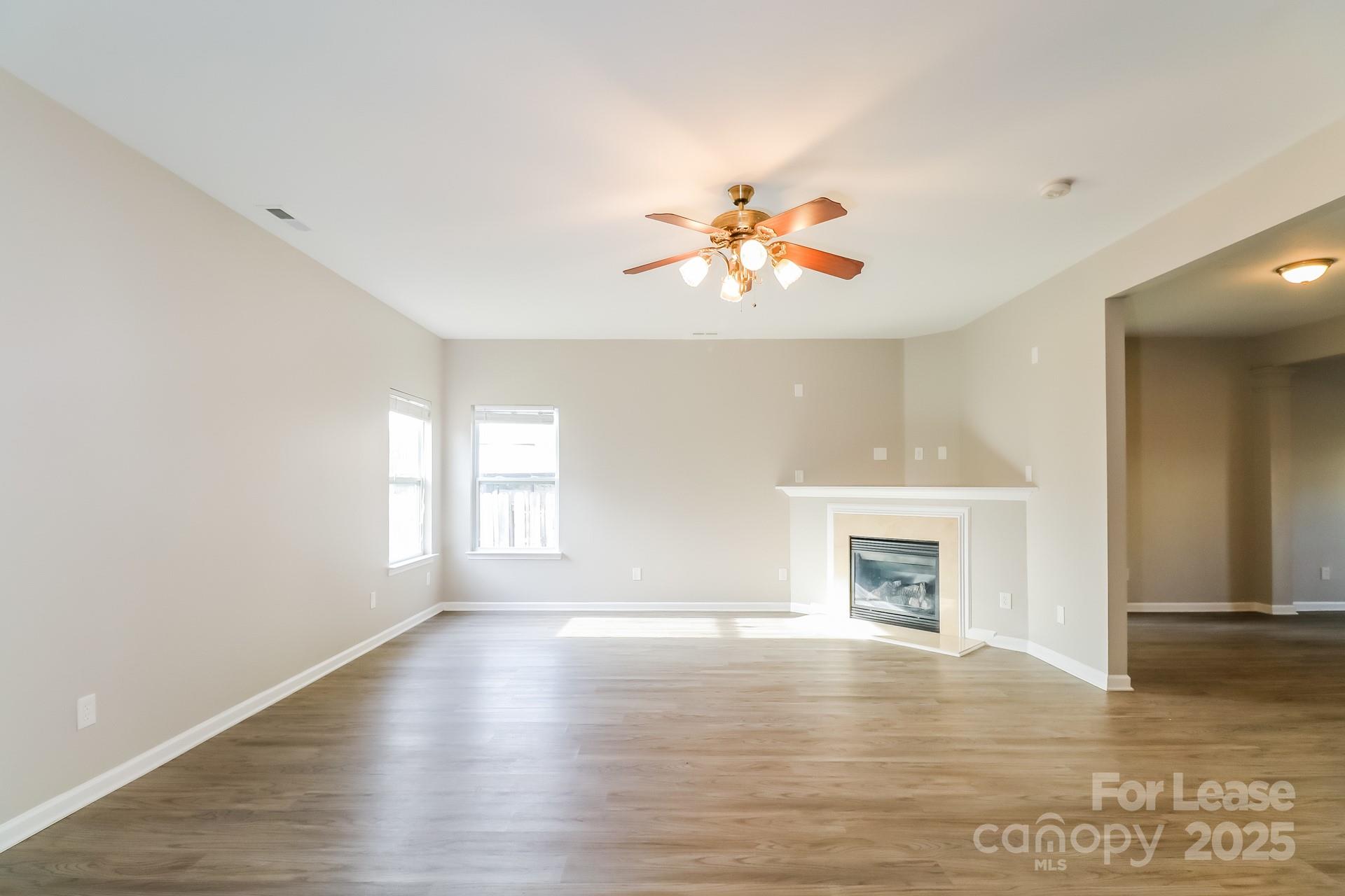 10901 Slalom Hill Road Charlotte, NC 28278 - Photo 4 of 17 an empty room with wooden floor and a fireplace