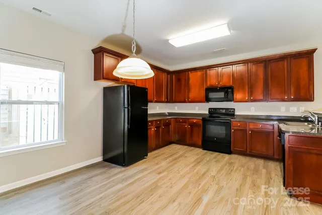 a kitchen with stainless steel appliances granite countertop a stove a sink dishwasher and a refrigerator