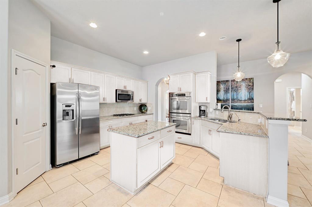 a large white kitchen with cabinets and stainless steel appliances