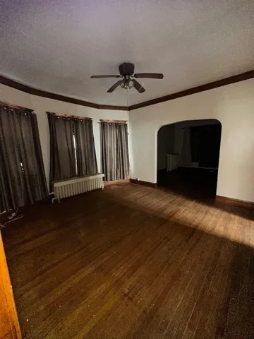 a view of a livingroom with wooden floor and a ceiling fan
