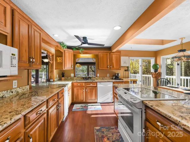 a kitchen with stainless steel appliances granite countertop a stove a sink and a refrigerator