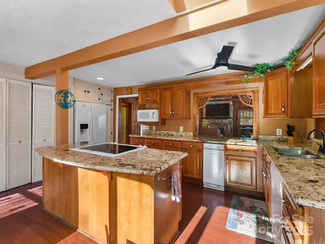 a kitchen with stainless steel appliances granite countertop a stove top oven a sink and a refrigerator